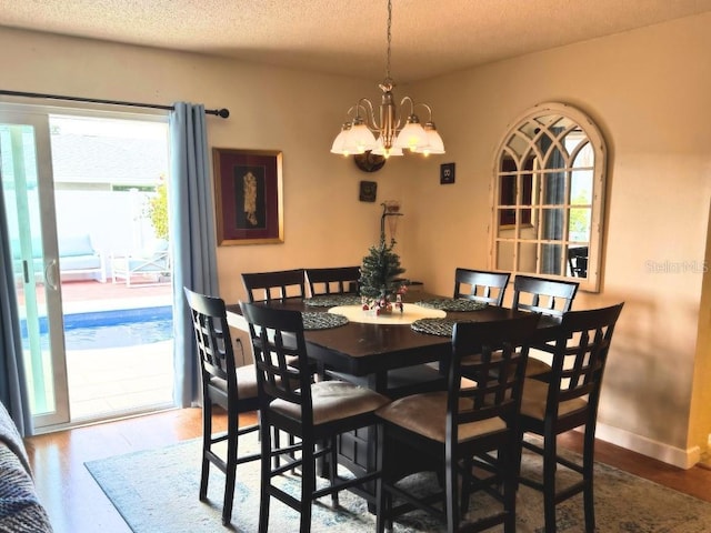 dining area with a textured ceiling and a notable chandelier