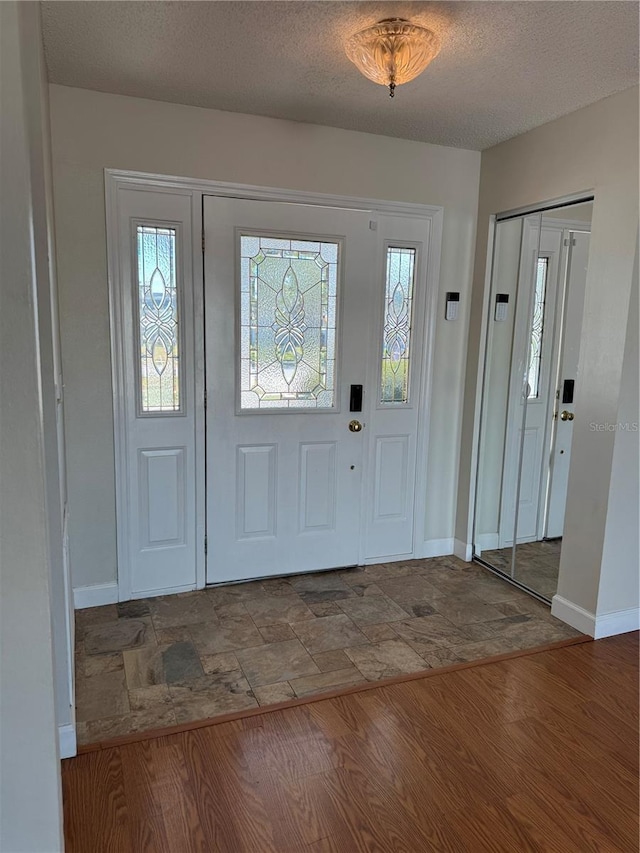 foyer featuring hardwood / wood-style flooring and a textured ceiling