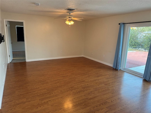 empty room with dark hardwood / wood-style floors, a textured ceiling, and ceiling fan