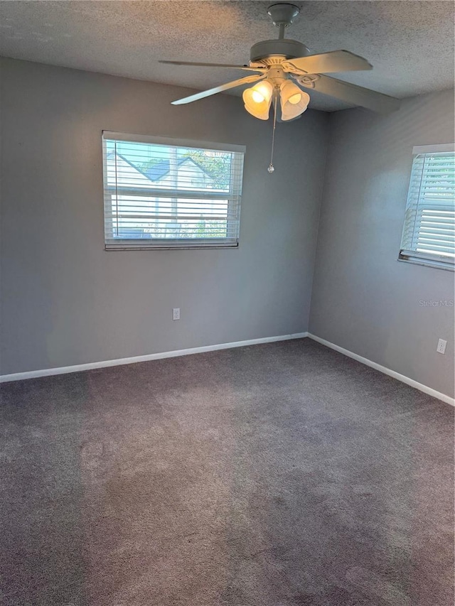 empty room featuring ceiling fan, carpet floors, and a textured ceiling