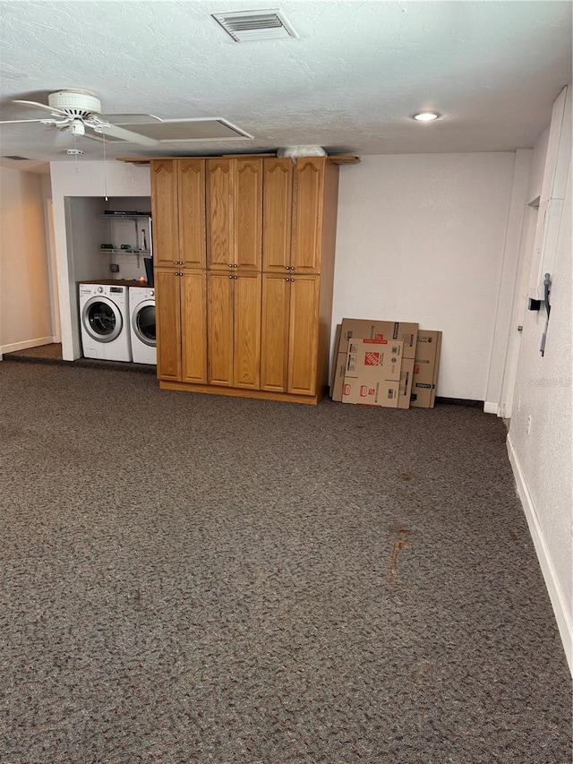 basement featuring ceiling fan, dark carpet, washer and clothes dryer, and a textured ceiling