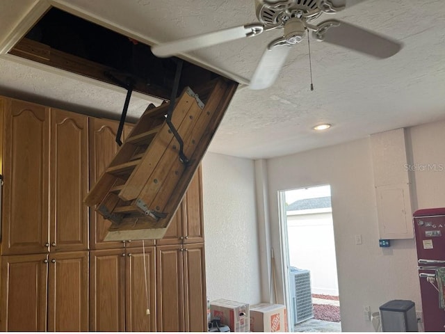 interior space with ceiling fan and a textured ceiling