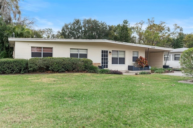 single story home featuring a front lawn and a carport