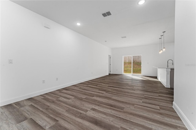 unfurnished living room featuring dark hardwood / wood-style flooring and sink