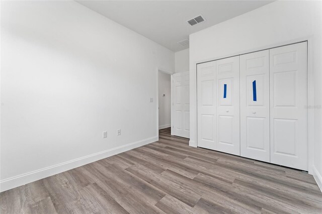 unfurnished bedroom featuring a closet and light hardwood / wood-style floors