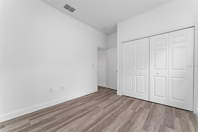 unfurnished bedroom featuring light hardwood / wood-style floors and a closet