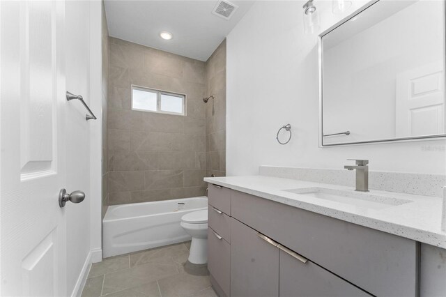 full bathroom featuring tile patterned flooring, toilet, vanity, and tiled shower / bath