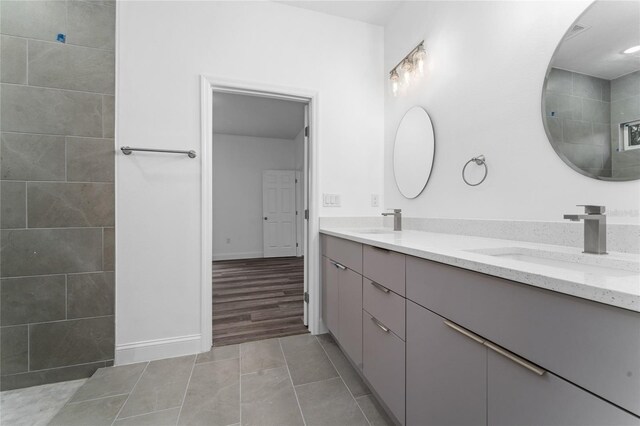 bathroom with tile patterned flooring, a shower, and vanity