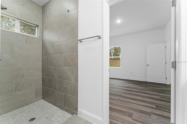 bathroom featuring tiled shower, hardwood / wood-style flooring, and a wealth of natural light