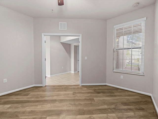 spare room with ceiling fan and light wood-type flooring