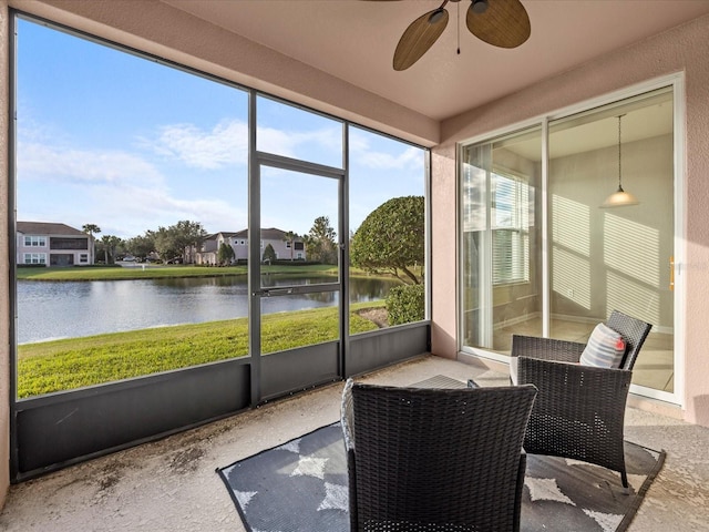 sunroom / solarium featuring a water view and ceiling fan