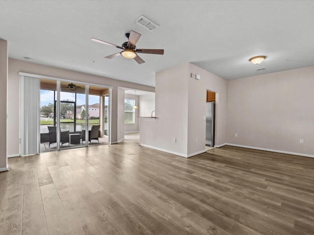 unfurnished living room with wood-type flooring and ceiling fan