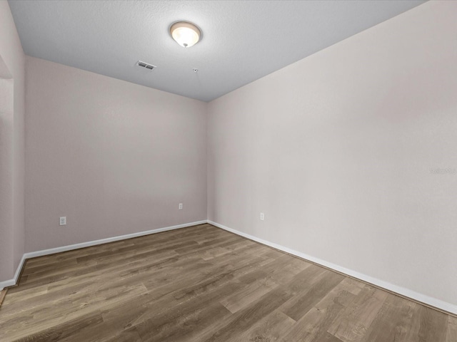 spare room with hardwood / wood-style floors and a textured ceiling