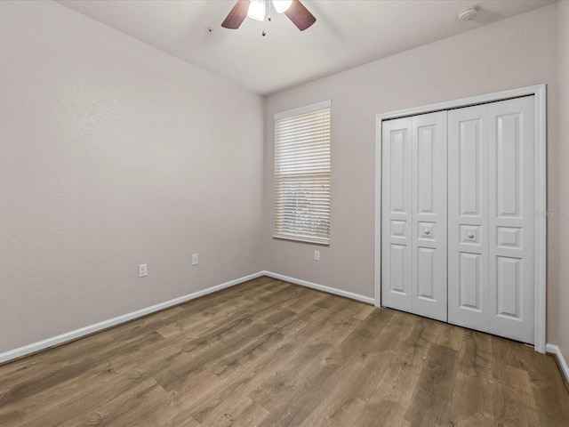 unfurnished bedroom featuring ceiling fan, hardwood / wood-style floors, and a closet