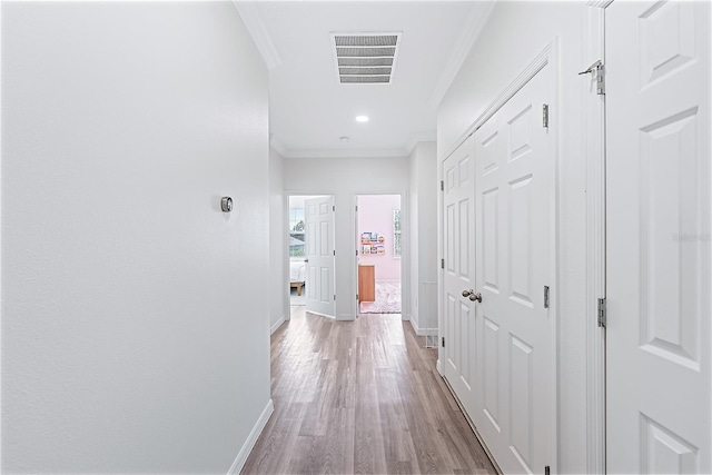 hall featuring light hardwood / wood-style floors and crown molding