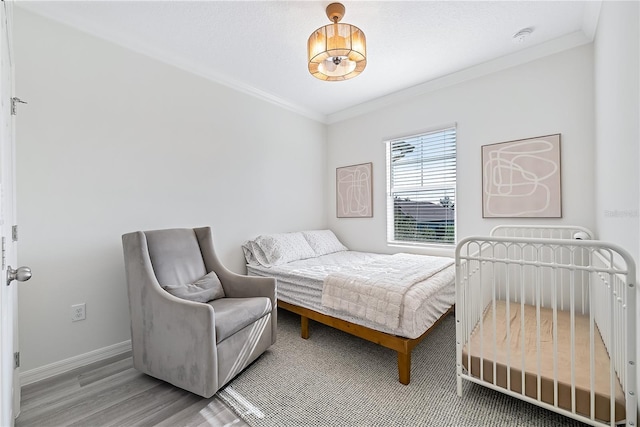 bedroom featuring hardwood / wood-style flooring and crown molding