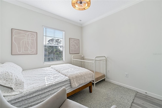 bedroom with light hardwood / wood-style floors and ornamental molding