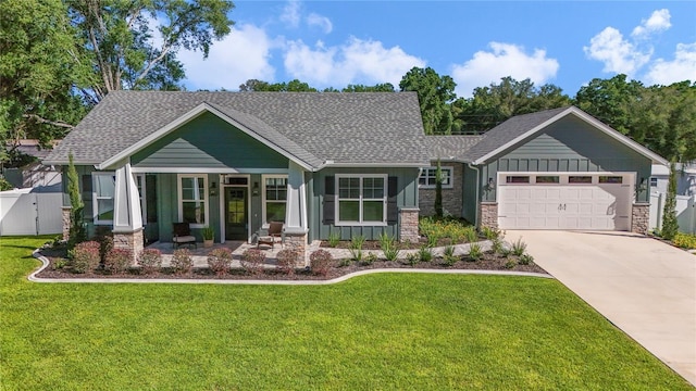 craftsman-style house with covered porch, a garage, and a front lawn