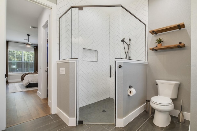 bathroom featuring ceiling fan, toilet, hardwood / wood-style floors, and tiled shower