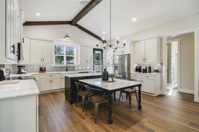 kitchen with pendant lighting, a center island, high end refrigerator, white cabinets, and beam ceiling