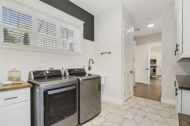 laundry area featuring cabinets, independent washer and dryer, a healthy amount of sunlight, and sink