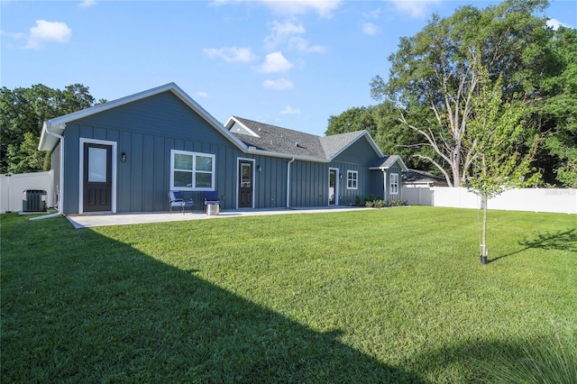 back of property featuring a patio, a yard, and central AC