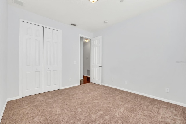 unfurnished bedroom with carpet flooring and a closet