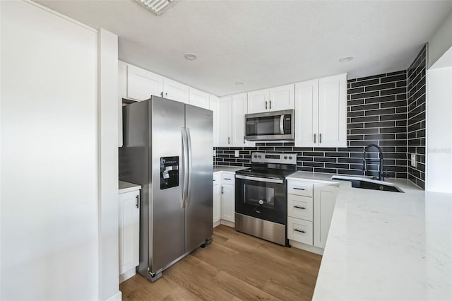 kitchen with sink, white cabinets, and stainless steel appliances