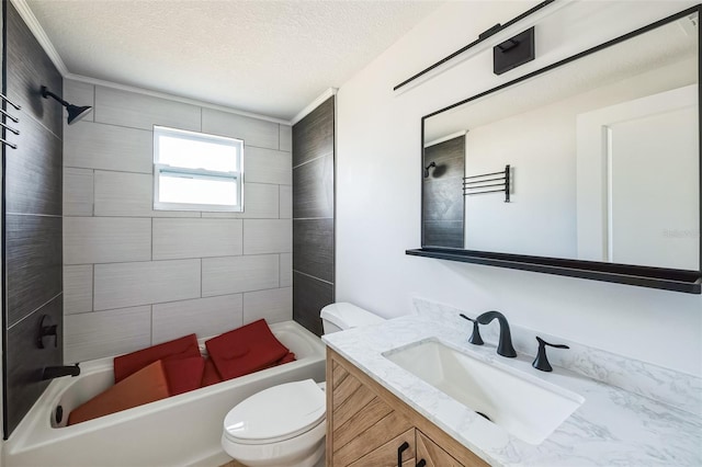 full bathroom featuring vanity, tiled shower / bath, toilet, ornamental molding, and a textured ceiling