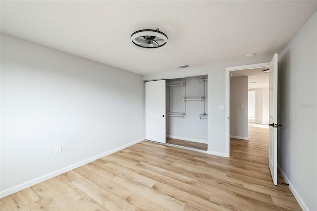 unfurnished bedroom with light hardwood / wood-style flooring and a closet