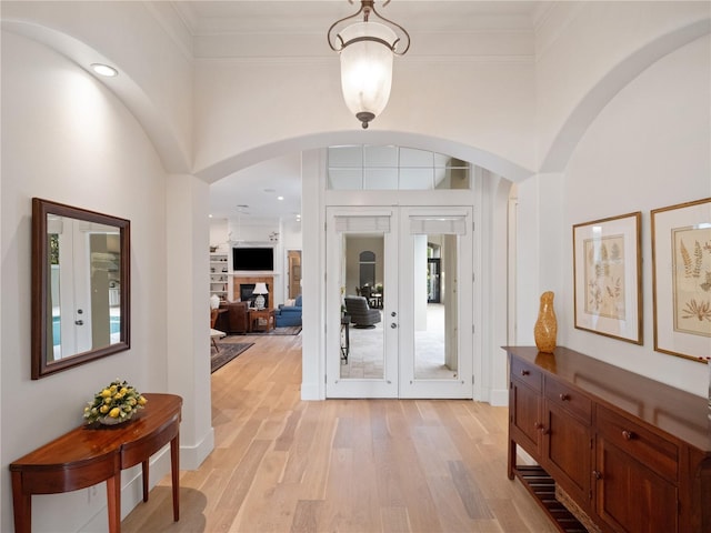 foyer with french doors, light hardwood / wood-style flooring, and ornamental molding