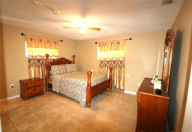 tiled bedroom with ceiling fan and a textured ceiling