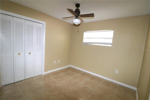 unfurnished bedroom featuring ceiling fan, a closet, and light tile patterned floors