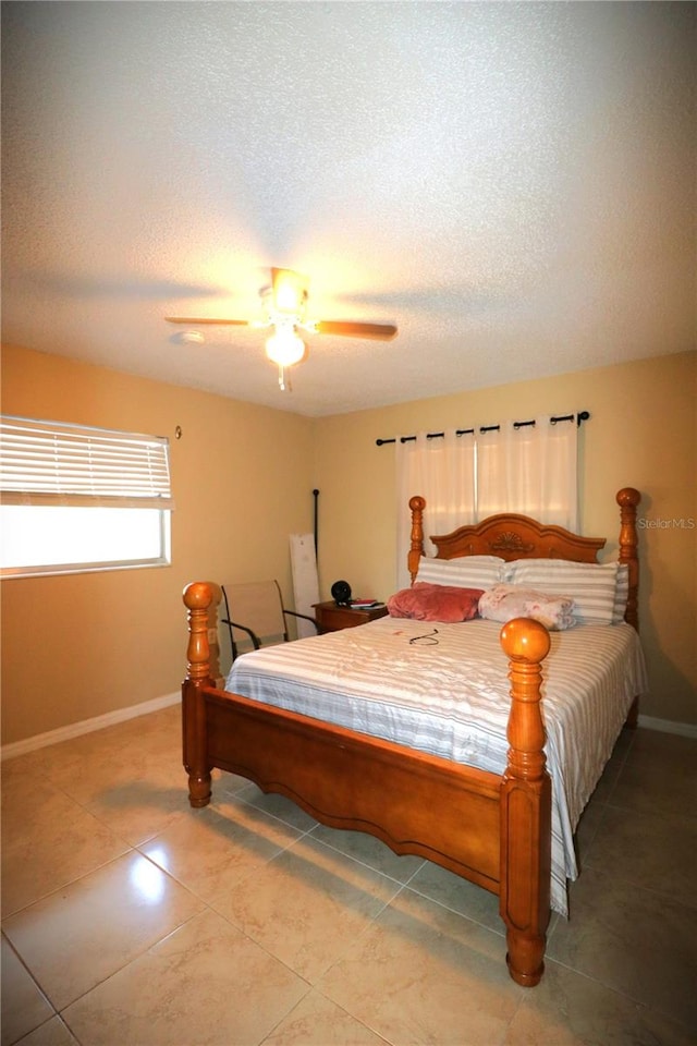 tiled bedroom with a textured ceiling and ceiling fan