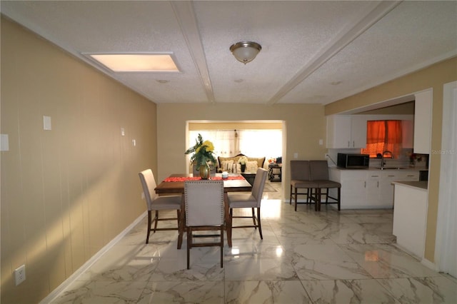 dining space featuring a textured ceiling and sink