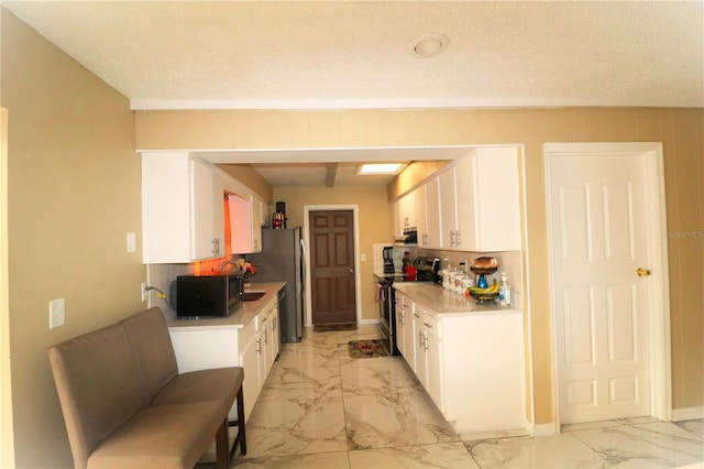 kitchen with white cabinetry, a textured ceiling, and appliances with stainless steel finishes