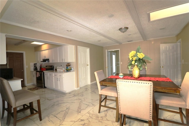 dining room featuring beam ceiling and a textured ceiling