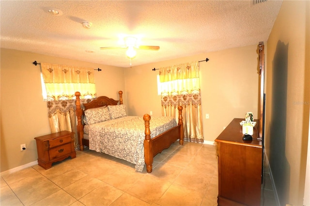 tiled bedroom featuring ceiling fan and a textured ceiling