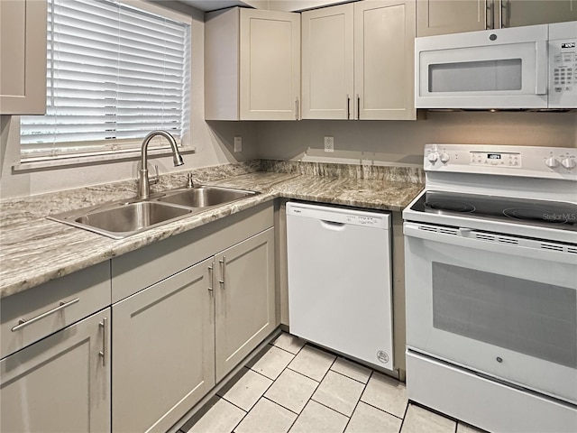 kitchen with light tile patterned floors, white appliances, and sink