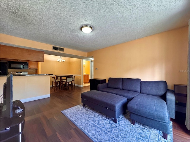 living room with a textured ceiling and dark hardwood / wood-style floors