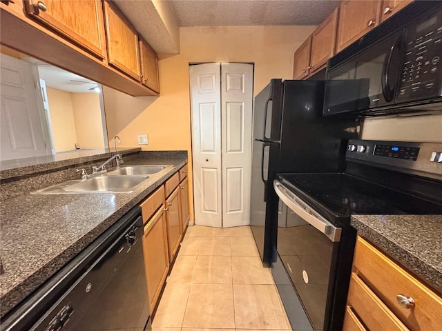 kitchen featuring light tile patterned flooring, a textured ceiling, sink, and black appliances