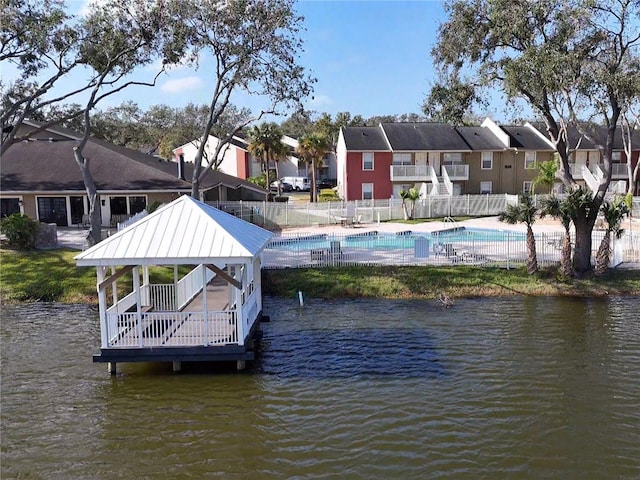 dock area with a gazebo, a water view, a fenced in pool, and a patio