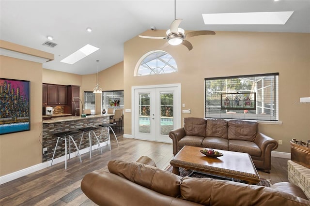 living room with ceiling fan, a skylight, wood-type flooring, and french doors