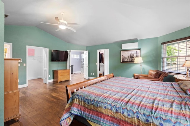 bedroom featuring a walk in closet, ceiling fan, a closet, and a wall mounted AC