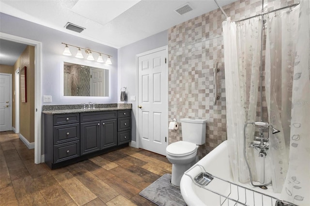 bathroom with vanity, tile walls, and toilet