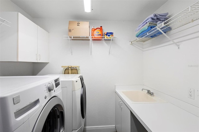 laundry room featuring cabinets, washing machine and clothes dryer, and sink