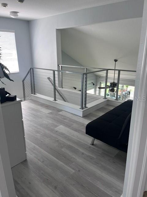 stairway with hardwood / wood-style floors, a chandelier, and vaulted ceiling