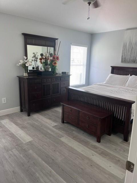 bedroom with light hardwood / wood-style flooring and ceiling fan