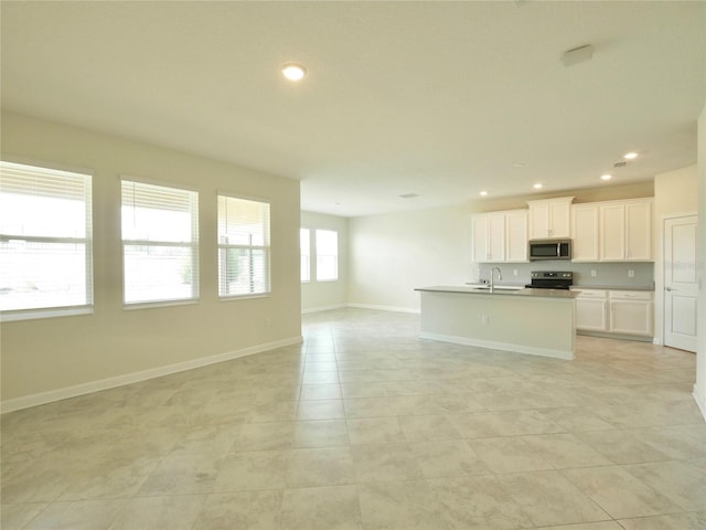 kitchen featuring a kitchen island with sink, white cabinets, sink, appliances with stainless steel finishes, and light tile patterned flooring