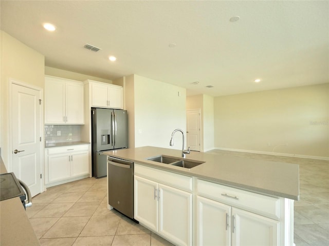 kitchen with sink, light tile patterned floors, an island with sink, appliances with stainless steel finishes, and white cabinetry